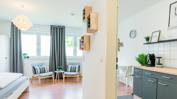 Un appartement moderne comprenant une chambre, un coin repas, une cuisine et un salon.