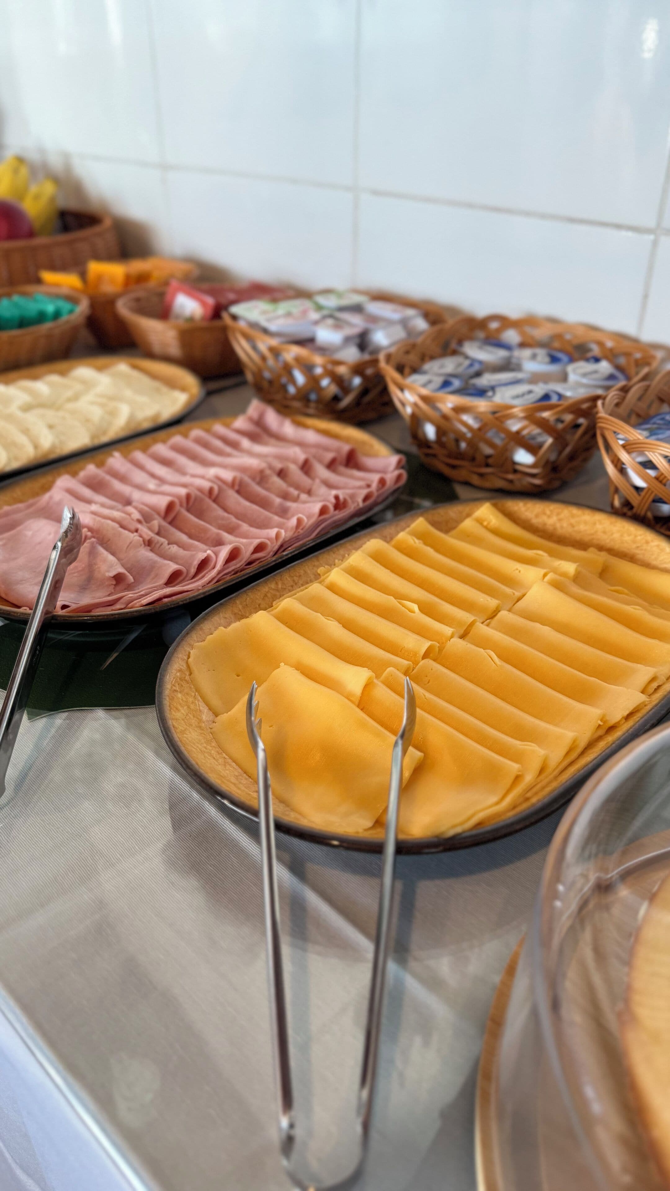 A buffet with various food items including sliced meats and pastries.