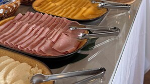 A buffet with various food items including pasta, ham, and desserts. - Pousada Mar da Vila (Cabo Frio)