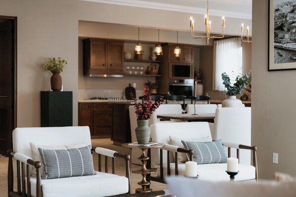 Una sala de estar moderna con comedor, y una cocina al fondo.