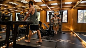 A gym with treadmills, weight machines, and a person using a treadmill.