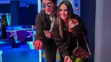 Two people in an indoor setting with gaming machines in the background.