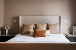 A bed with a headboard, multiple pillows, and two bedside tables with lamps. - Trobbu Boutique Collection San Miguel de Allende - All Inclusive (San Miguel de Allende)