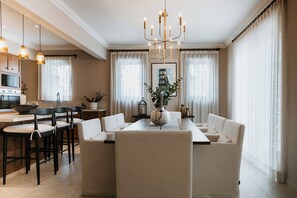A modern dining area with a long table, multiple chairs, and a chandelier. - Trobbu Boutique Collection San Miguel de Allende - All Inclusive (San Miguel de Allende)