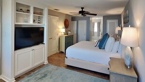 Un dormitorio con una cama grande, televisión y estanterías empotradas.