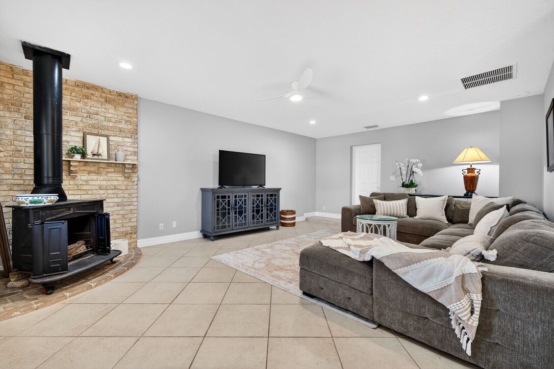 A living room with a fireplace, a sofa, a TV, and a lamp.