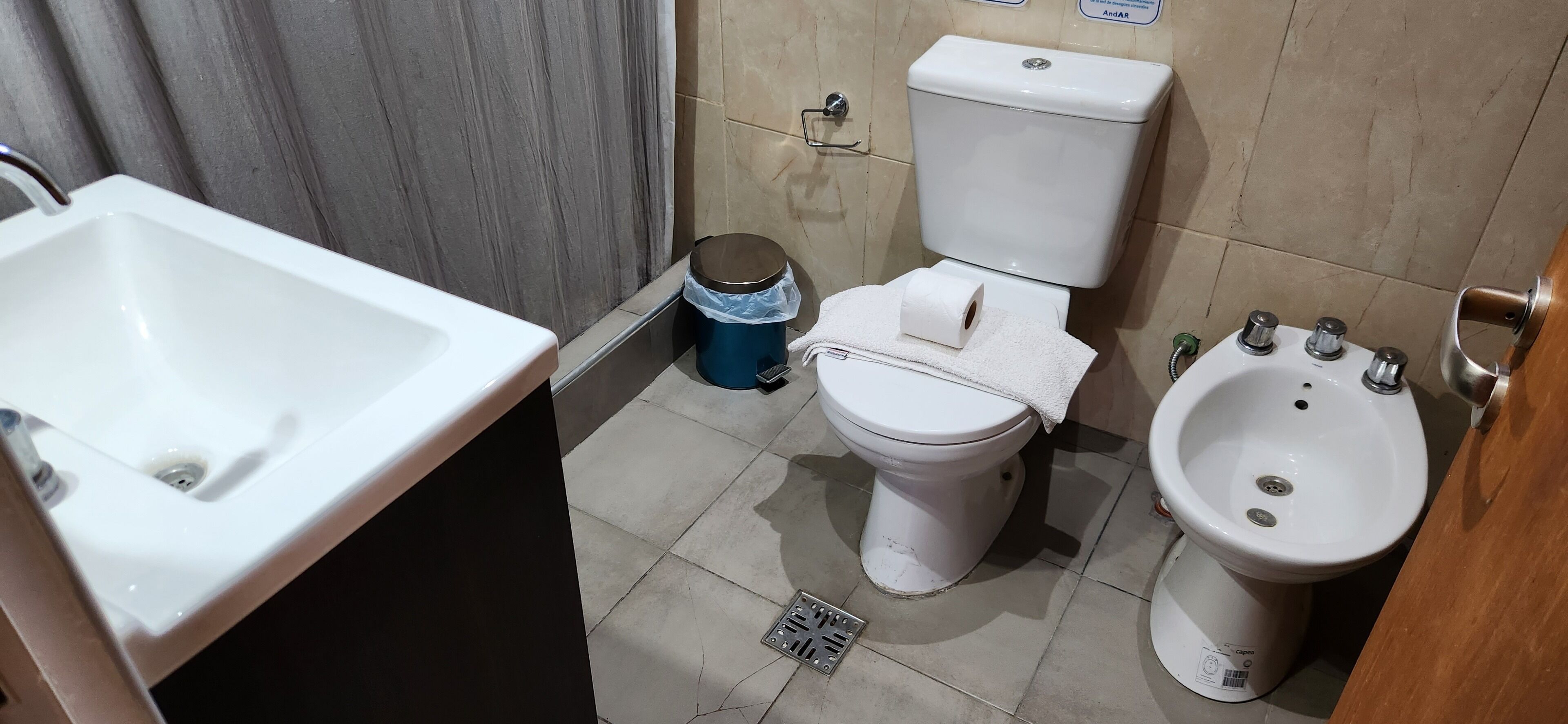 A bathroom with a white sink, toilet, and bidet.