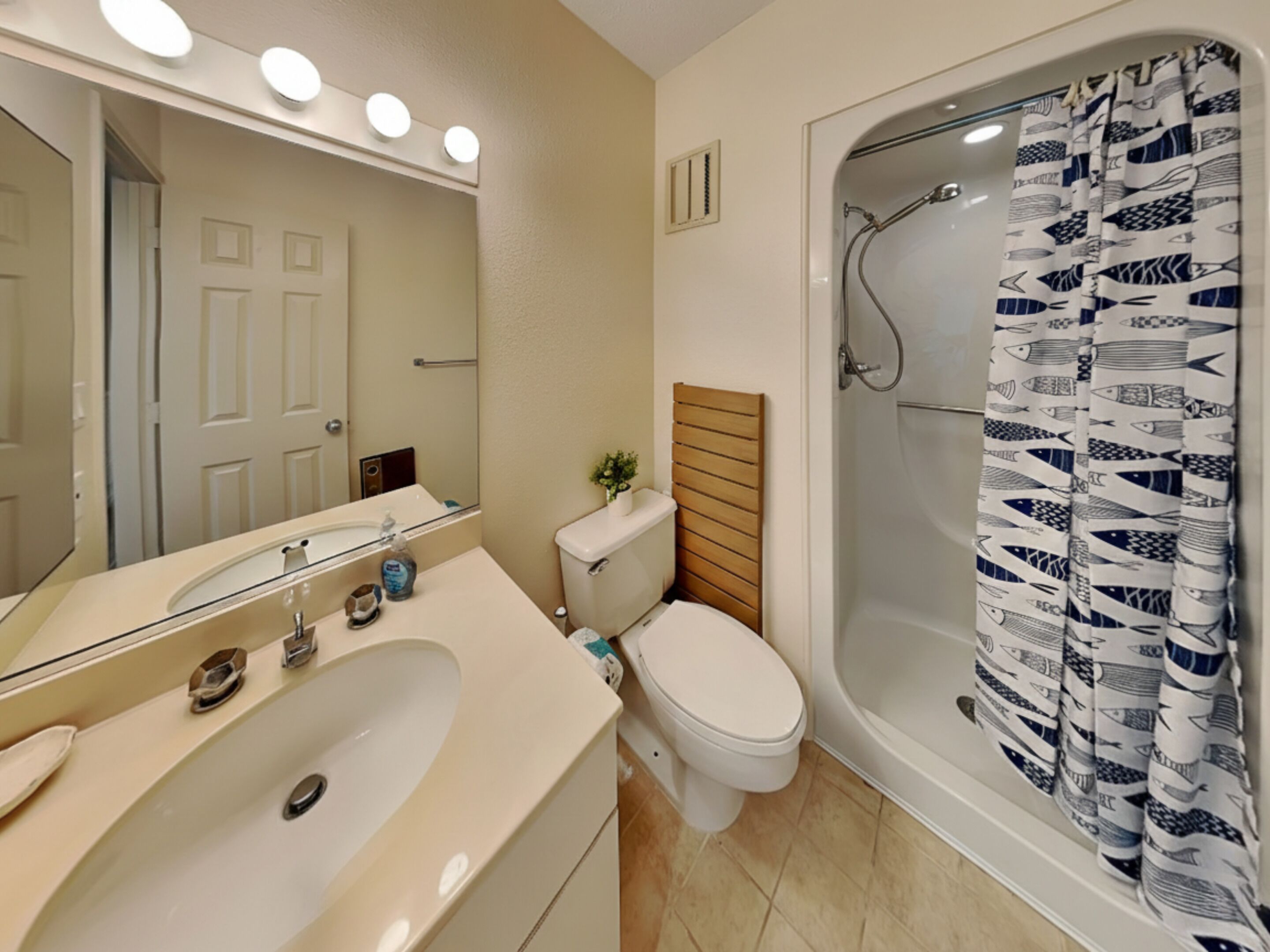 Un baño con lavamanos, inodoro y ducha.