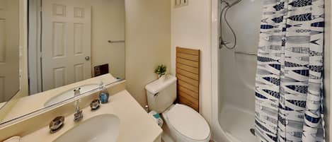 Un baño con lavamanos, inodoro y ducha.