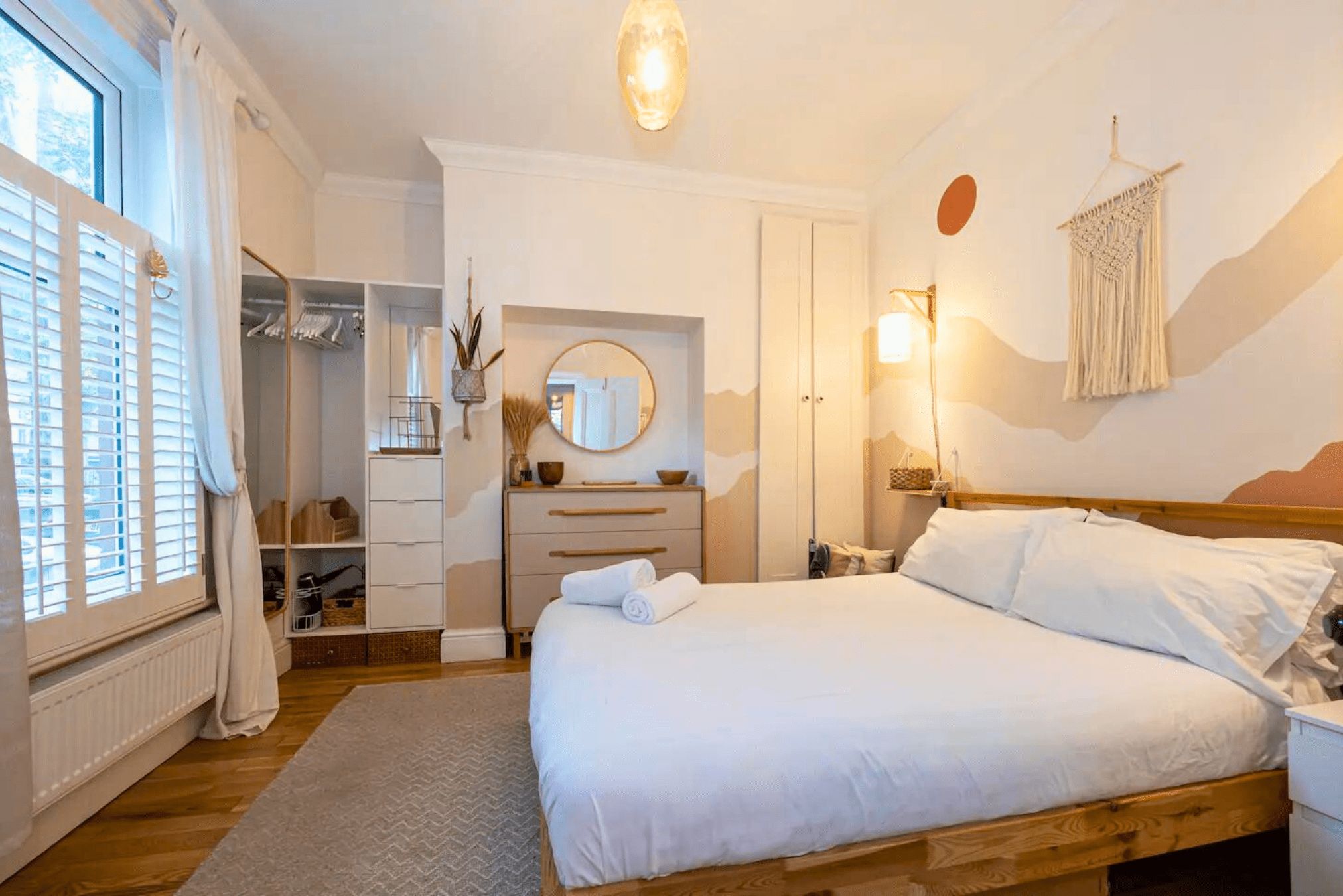A bedroom with a bed, bedside table, and a wardrobe.