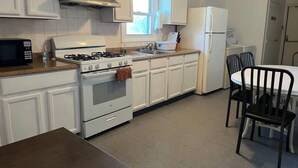 A kitchen with white cabinets, a stove, a microwave, and a refrigerator. - “The Retreat” with two balconies free parking (Atlantic City)