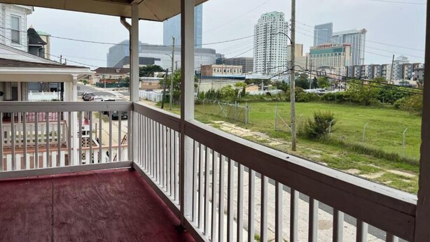 A balcony with a view of a cityscape, including high-rise buildings and a grassy area. - “The Retreat” with two balconies free parking (Atlantic City)