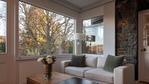 A modern living room with a sofa, a coffee table, and a vase of flowers.