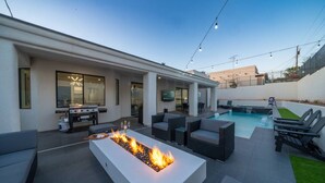 A modern outdoor living area with a pool, fire pit, and outdoor seating. - Havasu Hideaway: Modern Lux, Pool+Spa, Near Marina (Lake Havasu City)
