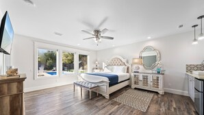 A bedroom with a bed, a ceiling fan, a large window, and a view of the outdoors. - Resort Feel Home, Private Pool,spa,hammocks. Beach,owa,wharf-15min, 5 Bedrooms (Foley)