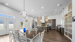 A spacious kitchen with white cabinetry, a central island, and pendant lighting. - Large Lux Home,private Pool,spa,backyard, 6 Bdrms, Beach,wharf, OWA 15 Mins Away (Foley)