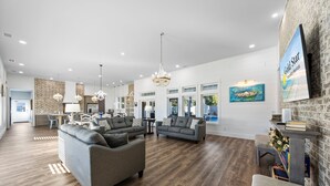 A spacious living area with a fireplace, large windows, and a chandelier. - Large Lux Home,private Pool,spa,backyard, 6 Bdrms, Beach,wharf, OWA 15 Mins Away (Foley)