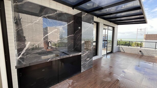 A modern kitchen with a marble backsplash, a built-in oven, and a view of the sea. - Flat Comfort La Belle Formosa - Cabedelo (Cabedelo)