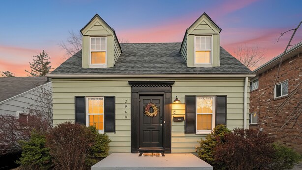 A two-story house with a dark front door, a wreath, and a mailbox. - Appealing 2br Cape Cod w/ bonus rm & fiber Wi-Fi! (Toledo)