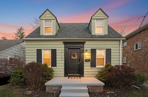 A two-story house with a dark front door, a wreath, and a mailbox. - Appealing 2br Cape Cod w/ bonus rm & fiber Wi-Fi! (Toledo)