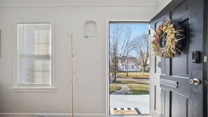 A front door with a wreath, a 'No Smoking' sign, a coat rack, and a mat. - Appealing 2br Cape Cod w/ bonus rm & fiber Wi-Fi! (Toledo)