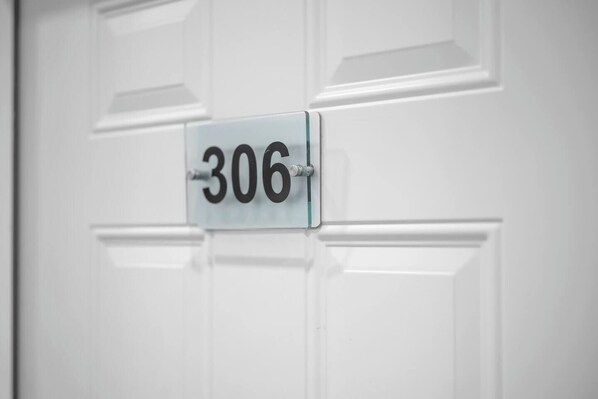 Une porte blanche avec une plaque portant le numéro « 306 ».