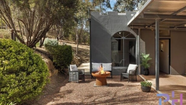 A modern outdoor patio with a fire pit, seating, and a covered area. - The Castle: Off-Grid Retreat nestled in the Sedgwick Valley 20 mins from Bendigo (Sedgwick)