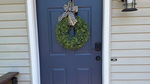 A dark blue door with a green wreath and a checkered bow, a mailbox, and a wall-mounted lantern. - Beach House w/ Huge Deck Amazing Views!! Kayaks, Swim, Fish! Golf Cart Rental! (Salem Lakes)