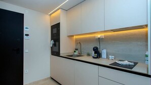 A modern kitchen with a built-in oven, a coffee machine, and a sink. - Luxury UCAM Studio | Desk & High-Speed Wi-Fi (Guadalupe)