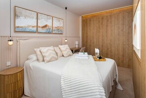 Une chambre à coucher bien aménagée, avec un grand lit, une tête de lit en bois et un panneau mural en bois.