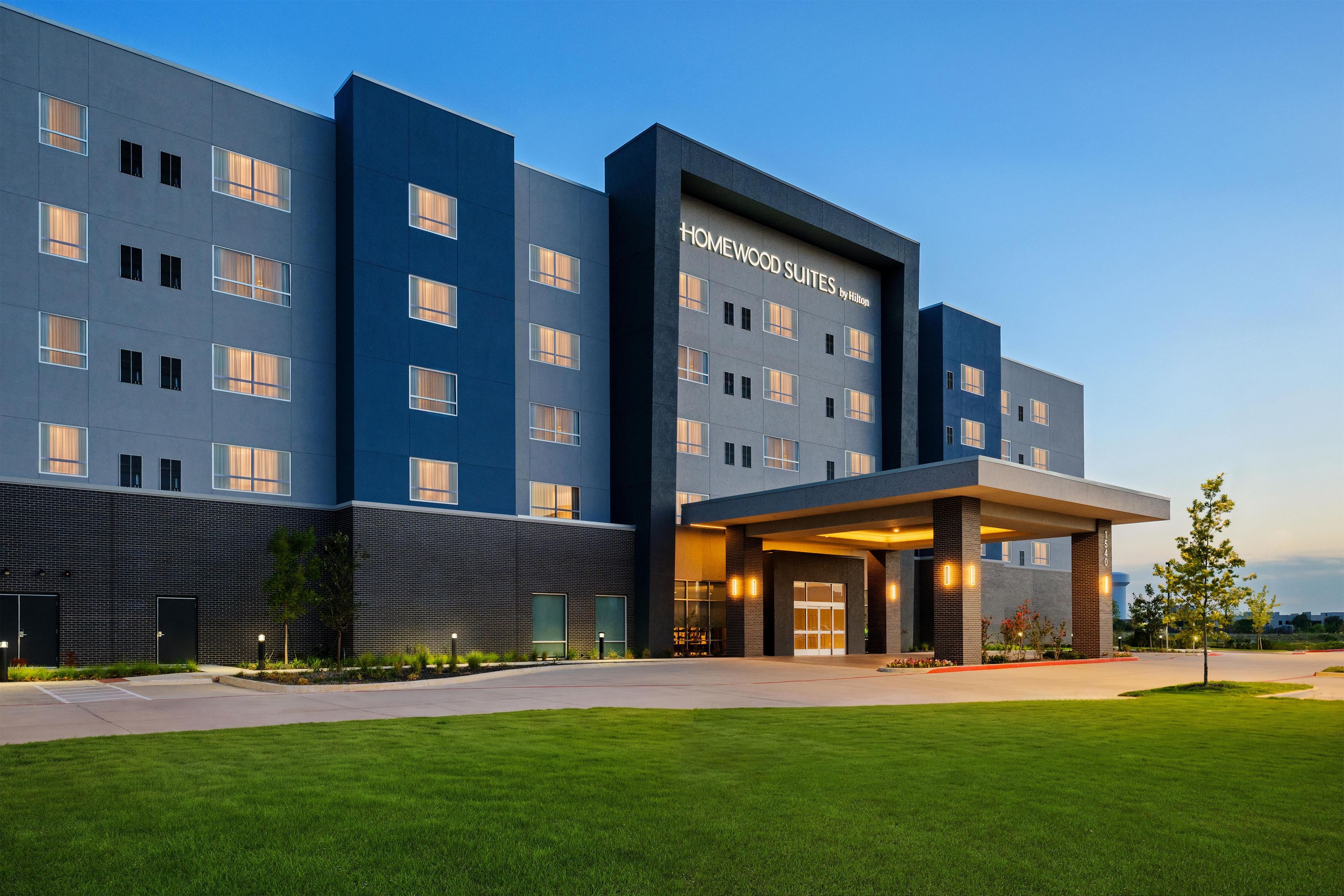 A modern hotel building with a flat facade, multiple windows, and a covered entrance area.