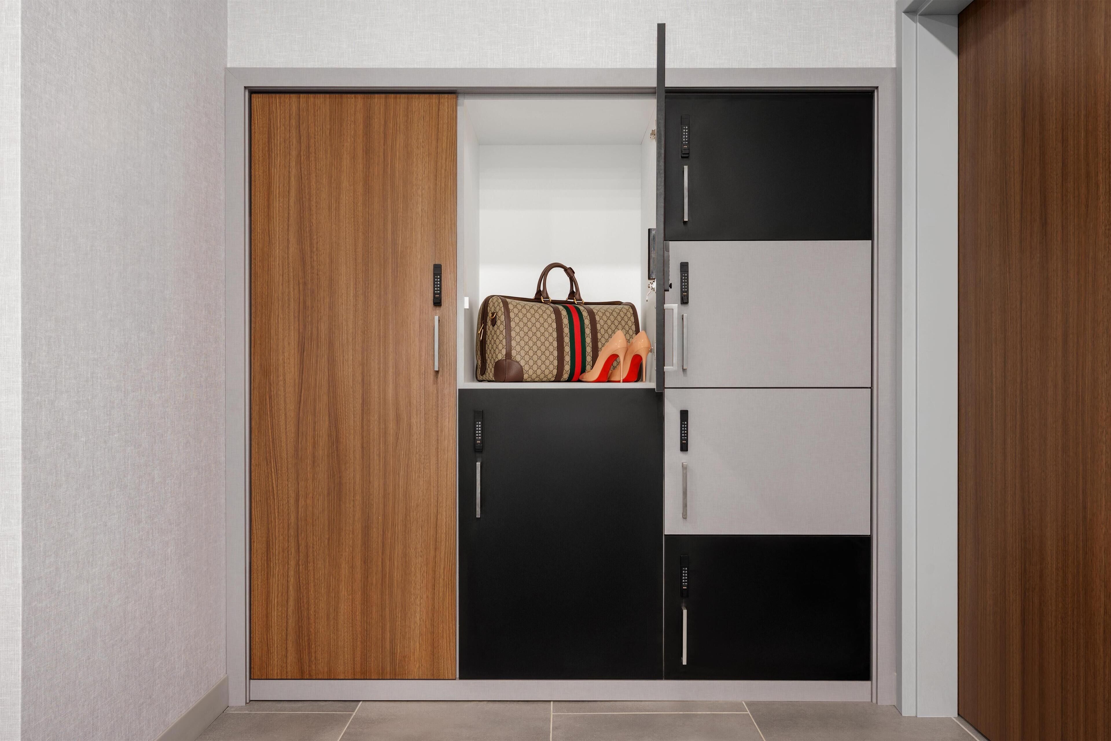 A wardrobe with a combination of wooden and black doors, featuring a hanging bag and shoes.