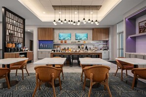 A modern kitchen with a central island, bar seating, and a dining area with chairs. - Homewood Suites By Hilton Coppell Dfw Airport North (Coppell)
