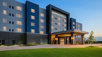 A modern hotel building with a flat facade, multiple windows, and a covered entrance area.