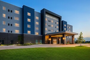 Un hotel moderno con fachada plana, numerosas ventanas y un área de entrada cubierta.