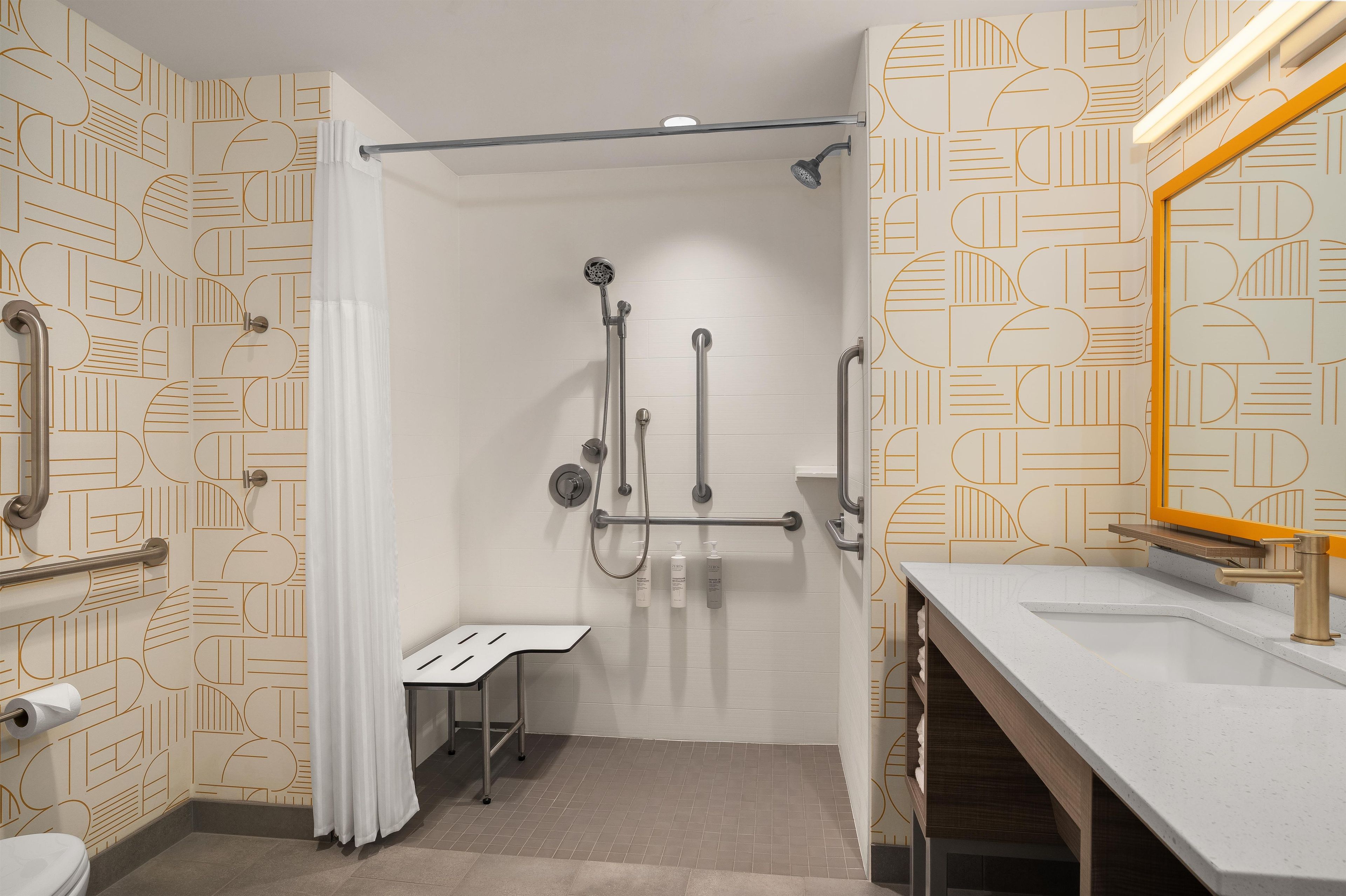 A modern bathroom with a shower, toilet, and sink.