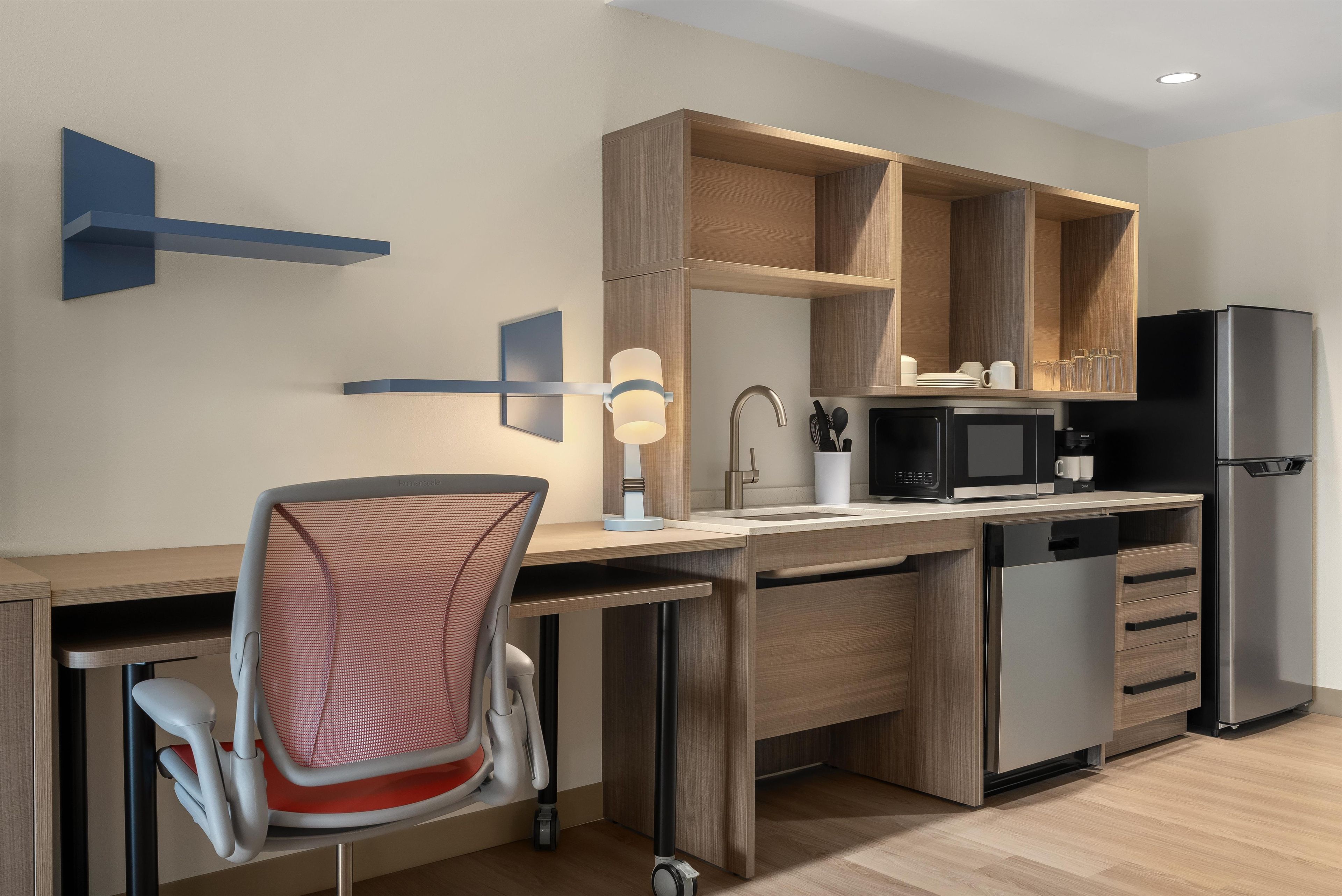 Una cocina moderna con lavavajillas incorporado, microondas y refrigerador.