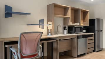 Una cocina moderna con lavavajillas incorporado, microondas y refrigerador.