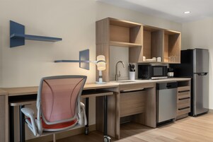 Una cocina moderna con lavavajillas incorporado, microondas y refrigerador.