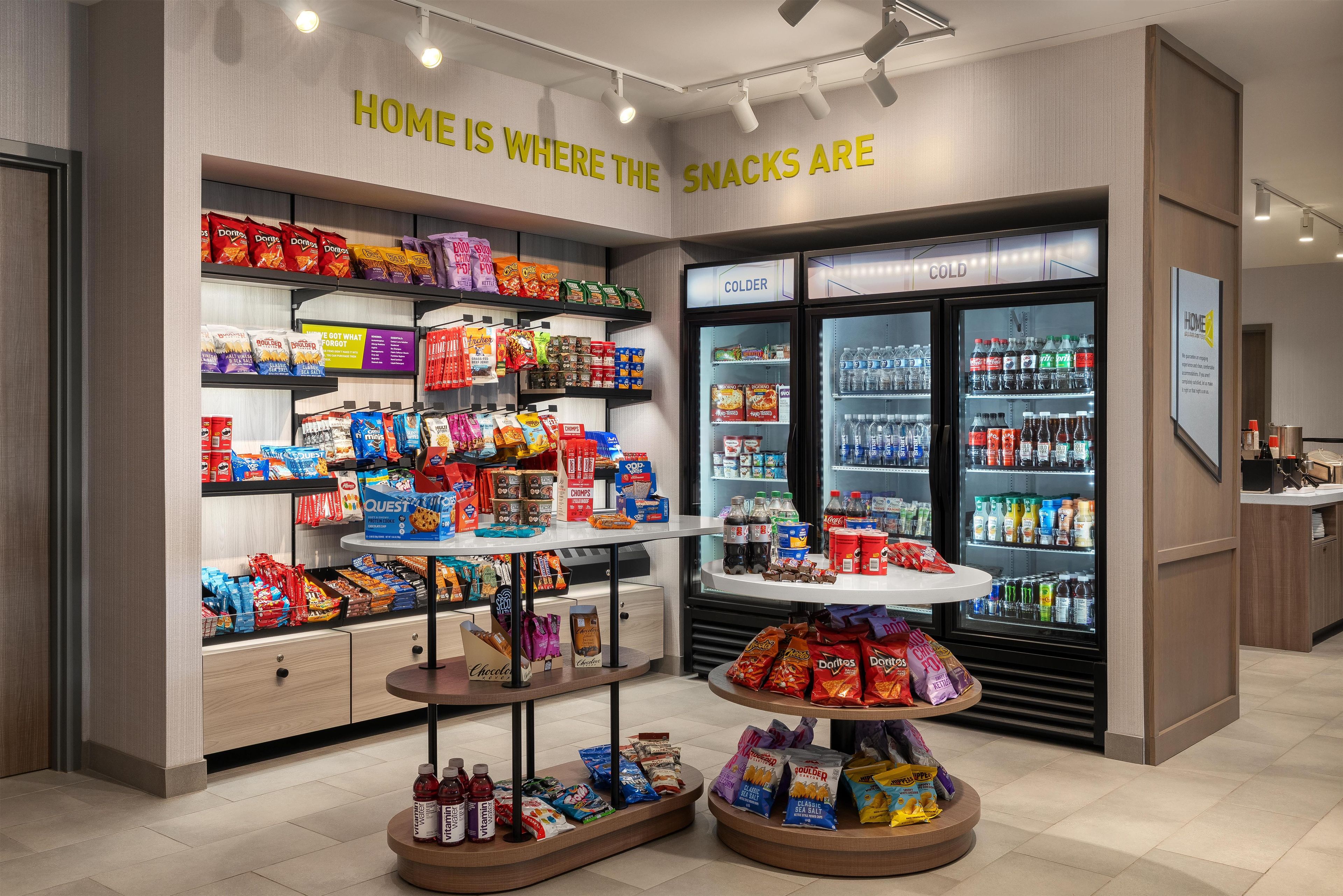 Een presentatiegedeelte met diverse snacks in verpakking en een koelgedeelte voor koude drankjes.