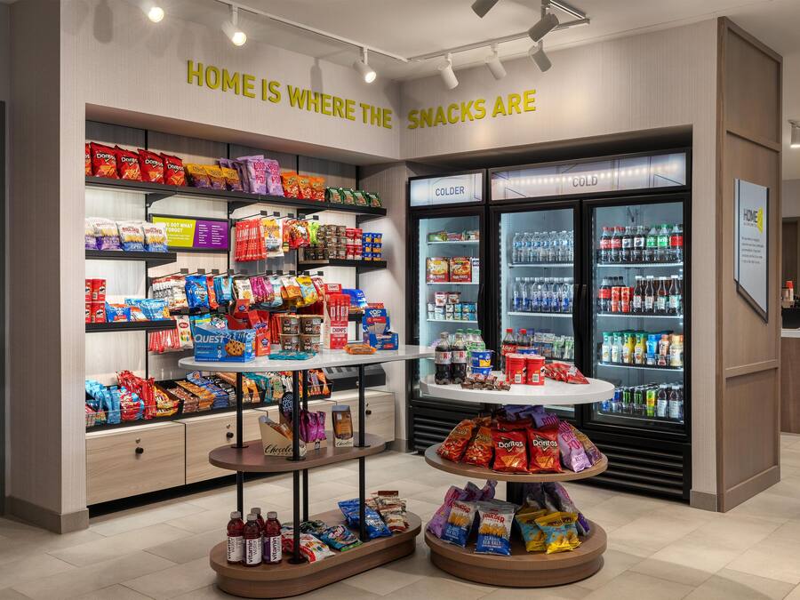 Een presentatiegedeelte met diverse snacks in verpakking en een koelgedeelte voor koude drankjes.