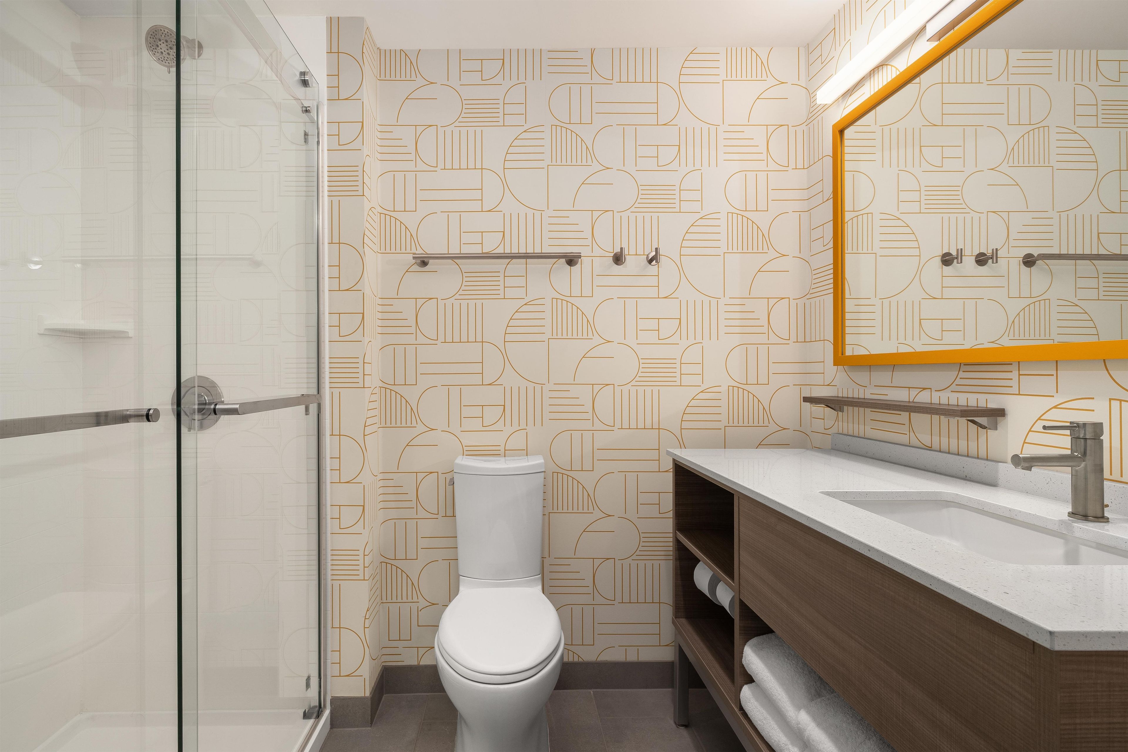 Un baño moderno con inodoro, ducha y tocador.