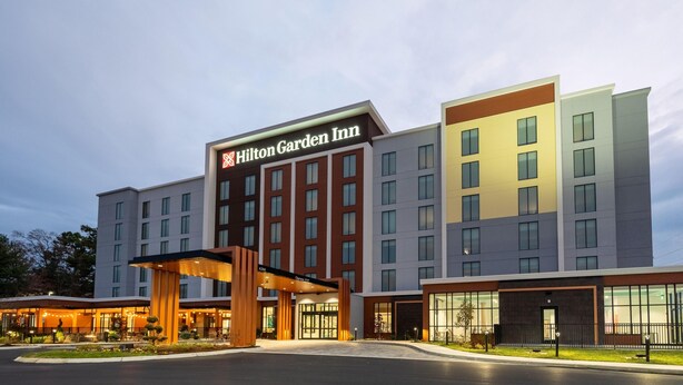 A Hilton Garden Inn hotel with a modern facade, multiple floors, and a well-lit entrance. - Hilton Garden Inn Kansas City Riverside (Riverside)