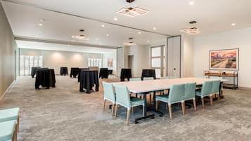 A conference room with a long table, chairs, and a large window.