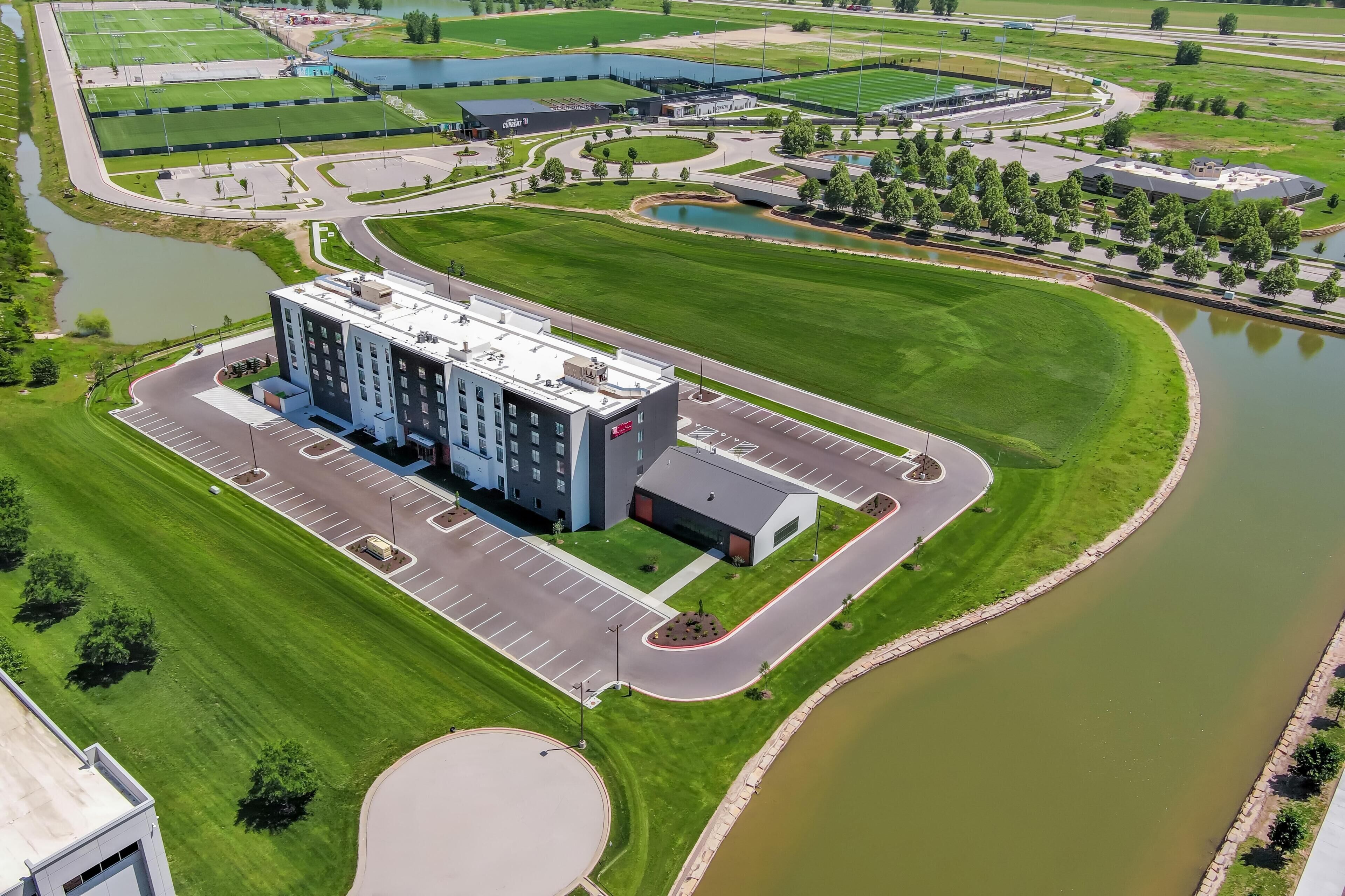 A modern building with a parking lot and a circular driveway.