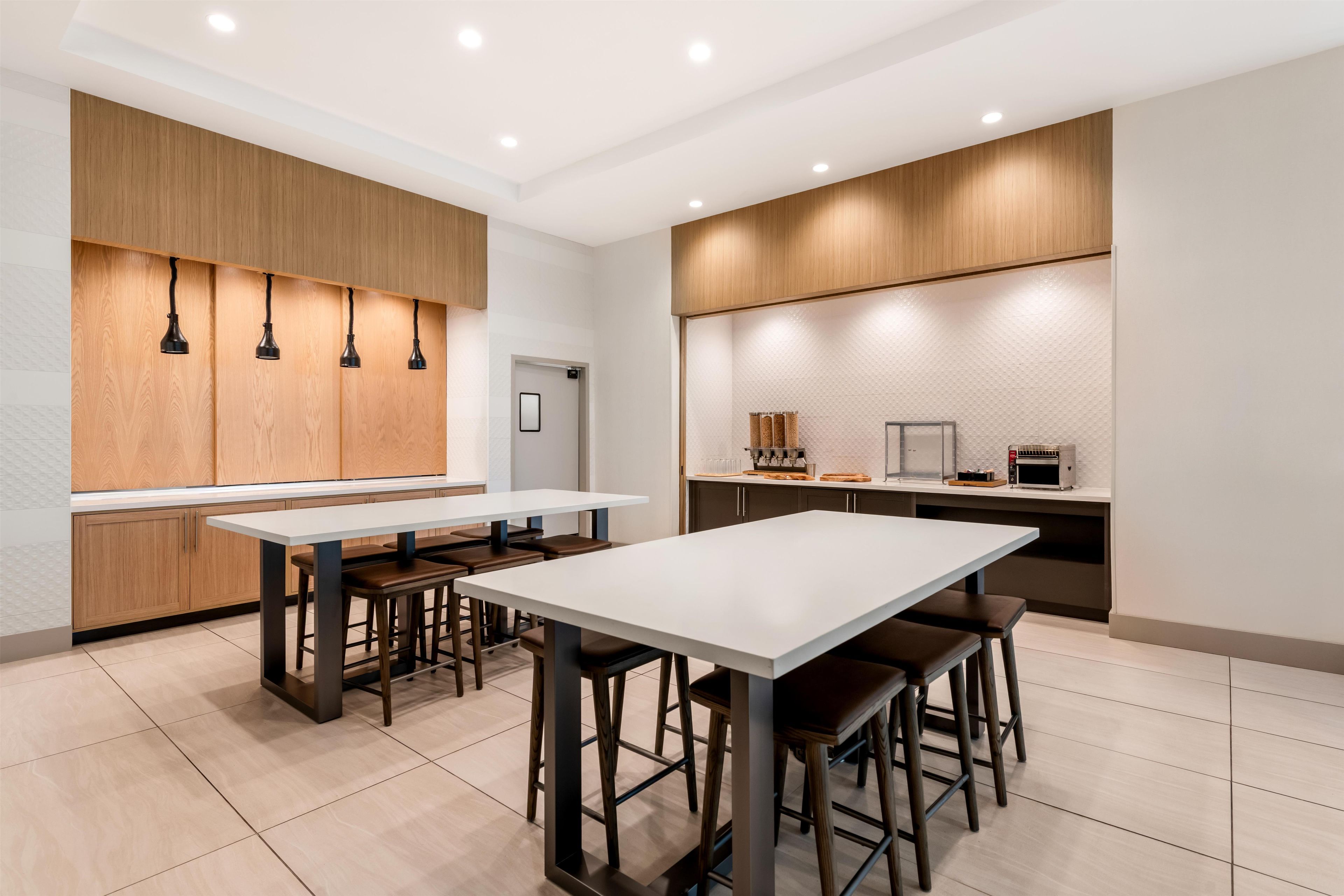 A modern kitchen with a central island, bar stools, and built-in appliances.
