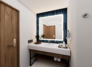 Un baño moderno con una puerta de madera, un lavabo blanco, un espejo con salpicadero de azulejos azules y una planta pequeña en la encimera.