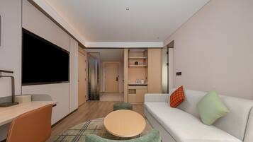 A modern living room with a sofa, a coffee table, and a TV.