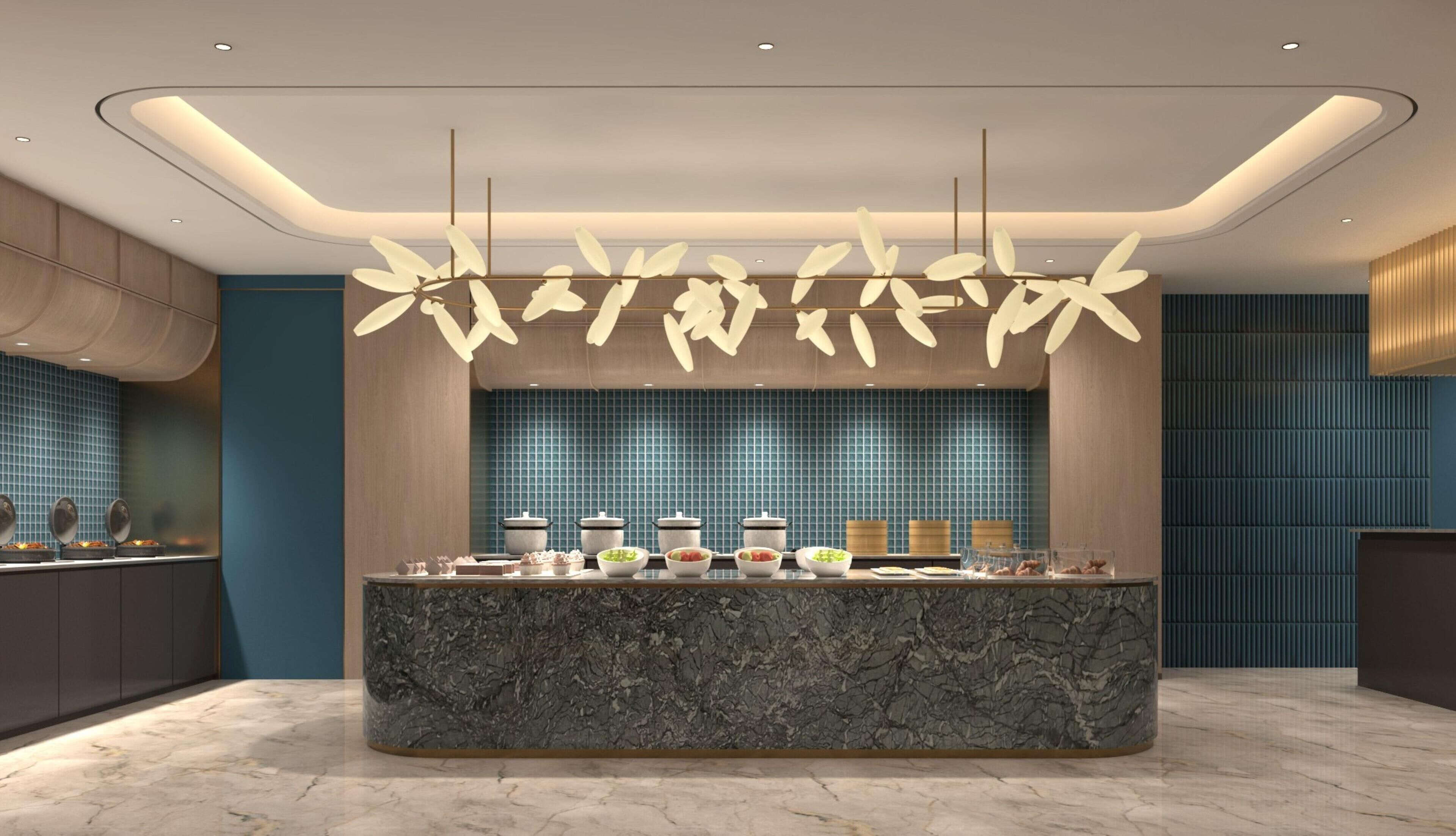 A modern kitchen with a marble island, blue tiled backsplash, and a unique leaf-shaped pendant light.