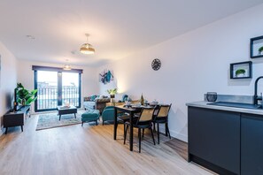 Eine moderne Wohnung mit Essbereich, Küche und einem Balkon mit Stadtblick.